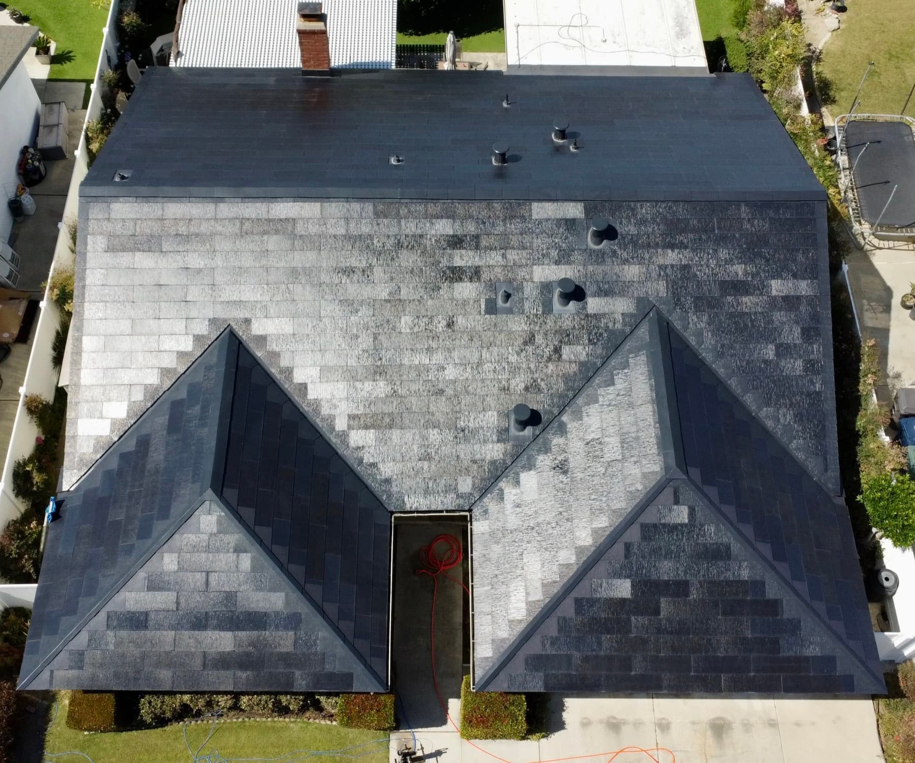 Drone view of a half-cleaned roof in Orange County showing the before and after contrast